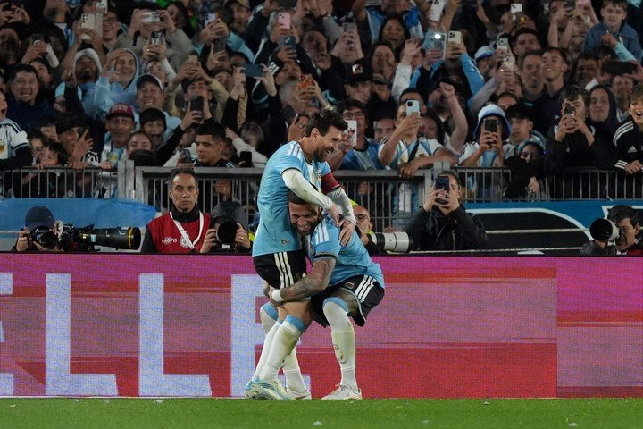 Otamendi levanta a Messi tras su gol ante Benín.
EFE/ Adán González